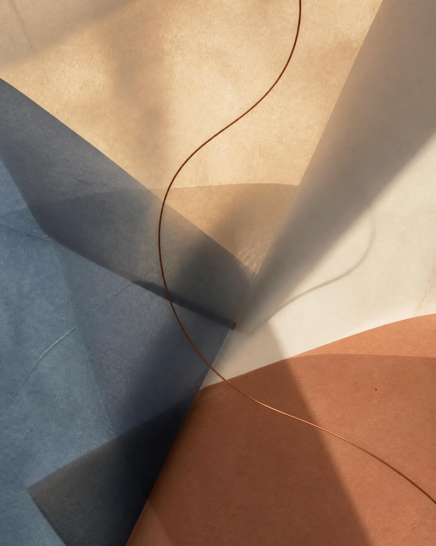 Abstract composition of overlapping translucent paper in sand, ink blue and clay tones